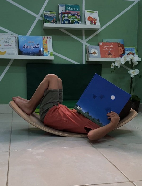 طفل يقرأ قصة في مكتبته