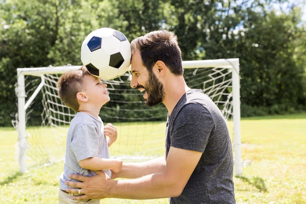 أب يلعب مع ابنه كرة قدم