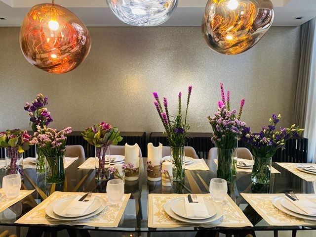 طاولة طعام مرتبة و مزينة بالورود البنفسجية لاستقبال الضيوف 