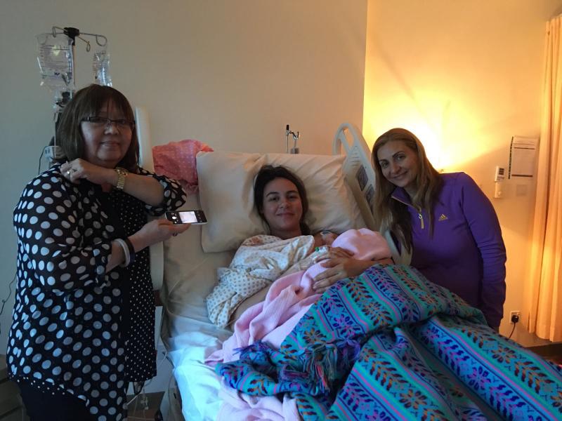 صورة لأم و طفلتها على سرير المشفى برفقة الدولا الخاصة بها  