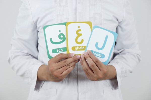معلم يمسك بطاقات حروف عربية