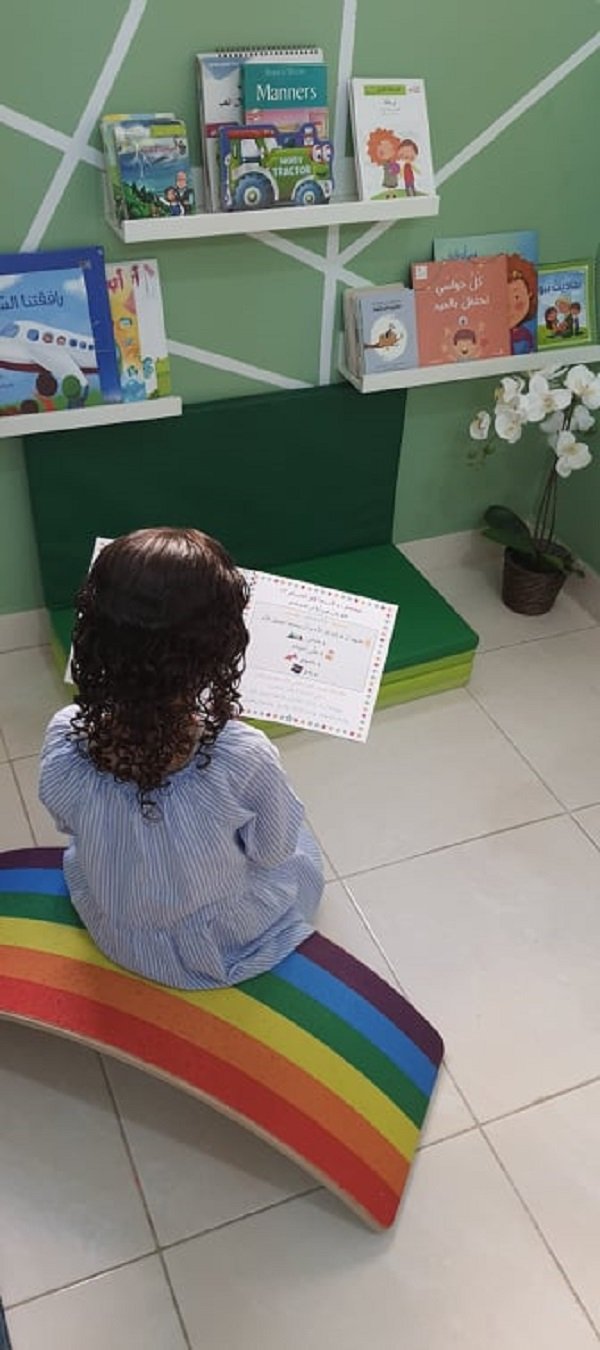 طفلة تقرأ وتطالع في زاوية كتب