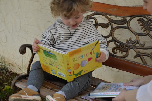 a little kid holding the youth journal and reading it