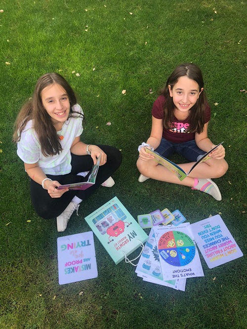 two girls reading books from the growth mindset kit 