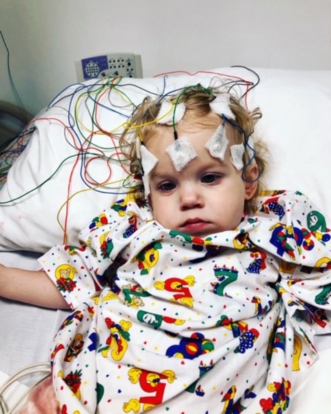 A child wearing the electroencephalogram devices on her head in the hospital