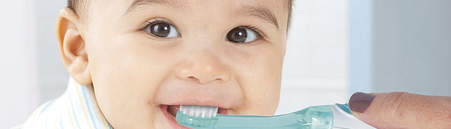 a kid brushing his teeth with the help of his mother