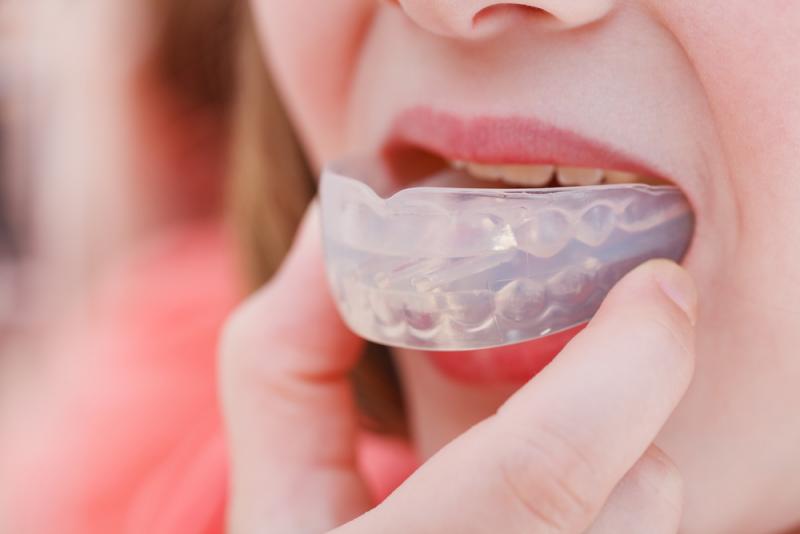 a kid wearing a mouth guard to protect his teeth 