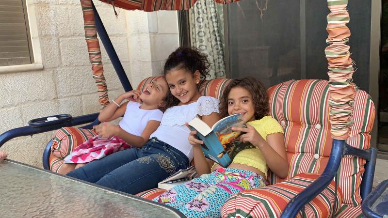 girls setting on a swing and reading books together