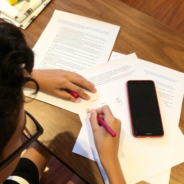 A kid studying near to his mobile phone