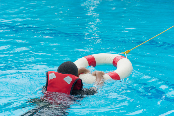 a kid swimming with a life jacket on 