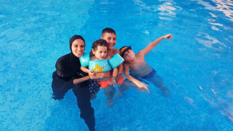 a mother with her three kids in a pool