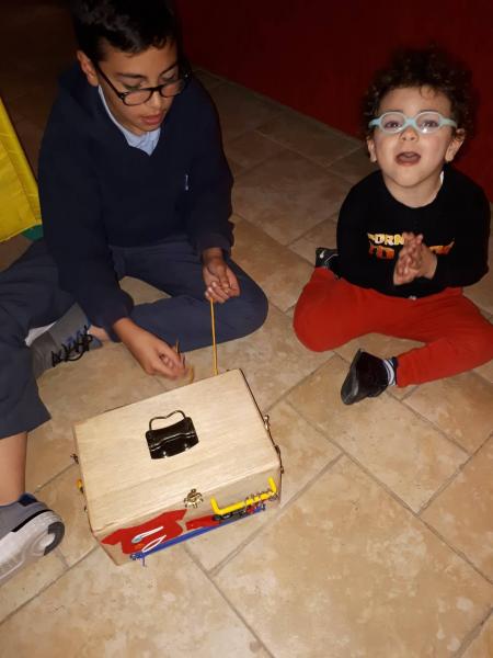 two kids setting on the floor and playing with a toy 