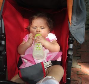 a girl drinking milk in a chair