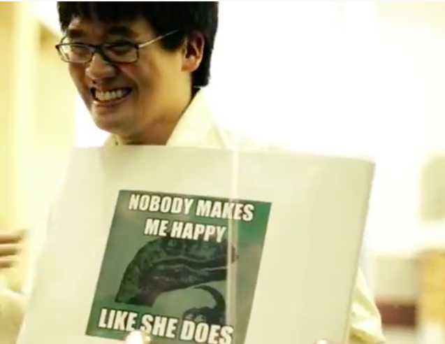 a guy holding a meme poster that says nobody makes me as happy as she does