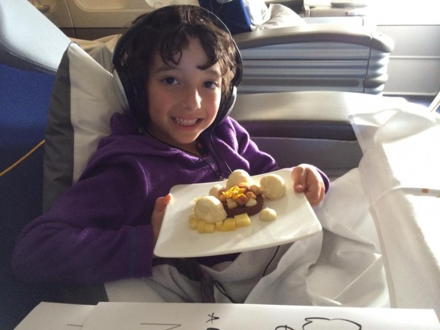 a kid eating a meal while traveling in an airplane