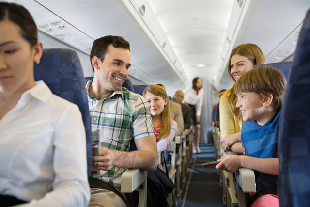 a family setting in their seats while airplane flies