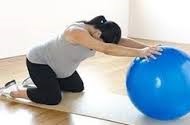  a pregnant mom practicing the Spinal Extension with Chair or Ball Support stretch 