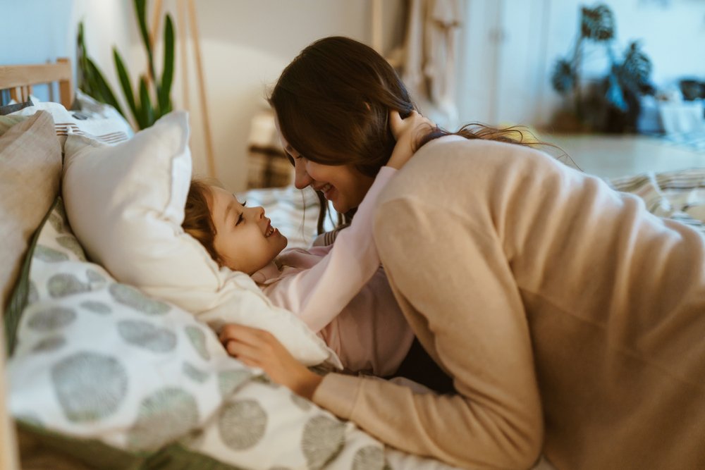 A mother taking her child to bed