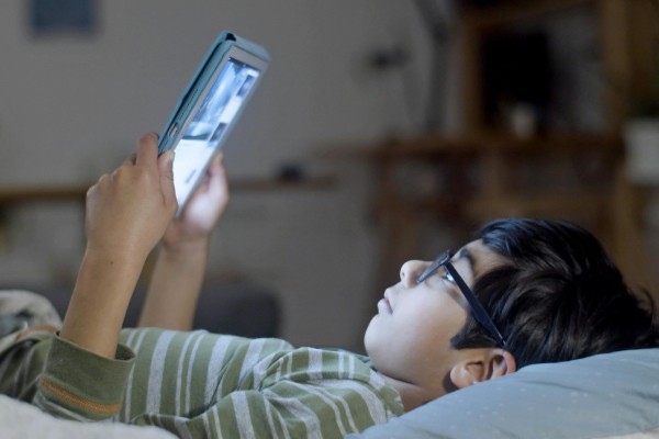 طفل يستخدم الشاشة والانترنت والتابلت في الليل